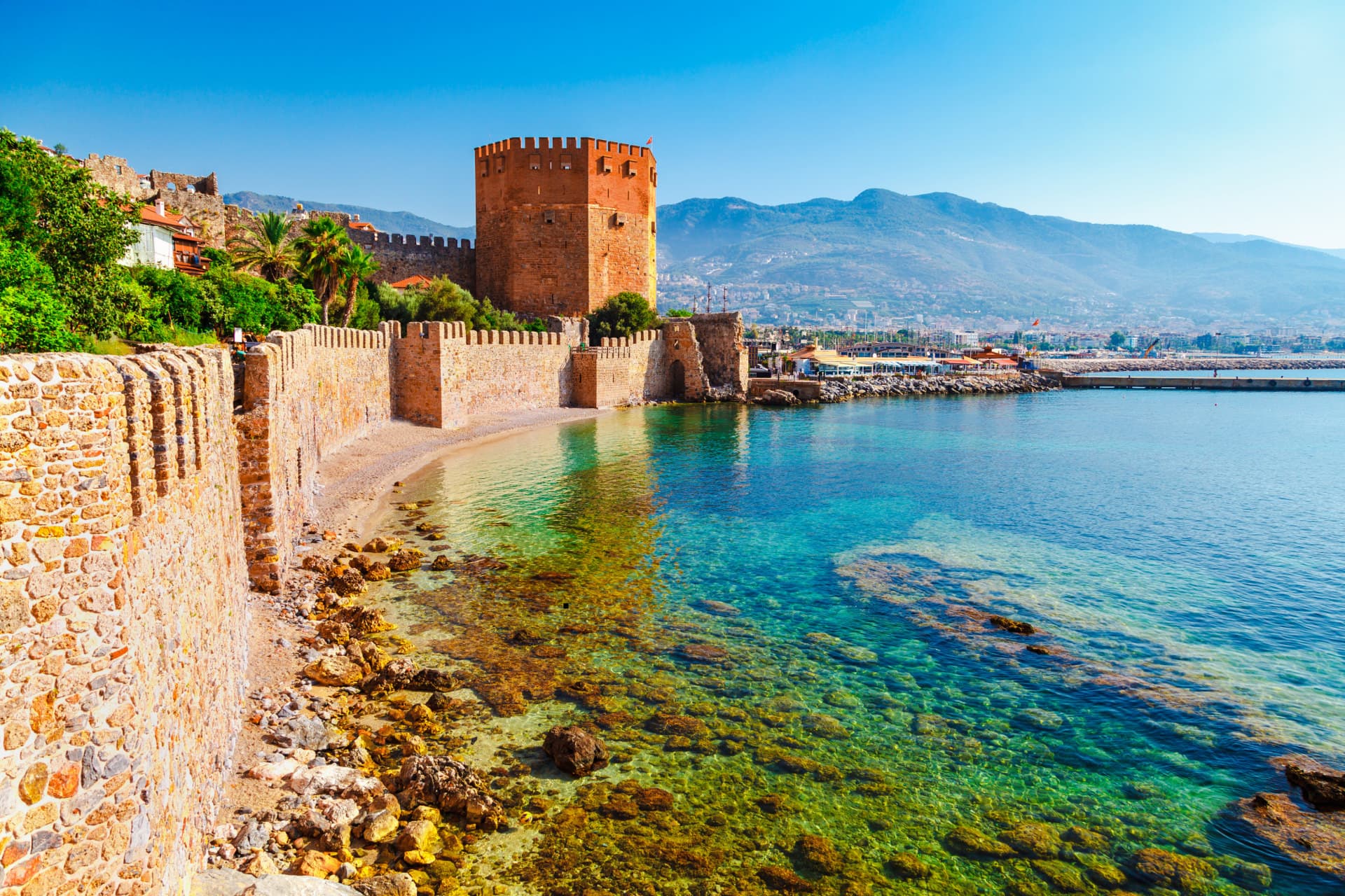 Turnul Roșu și zidurile cetății din Alanya deasupra apei limpezi