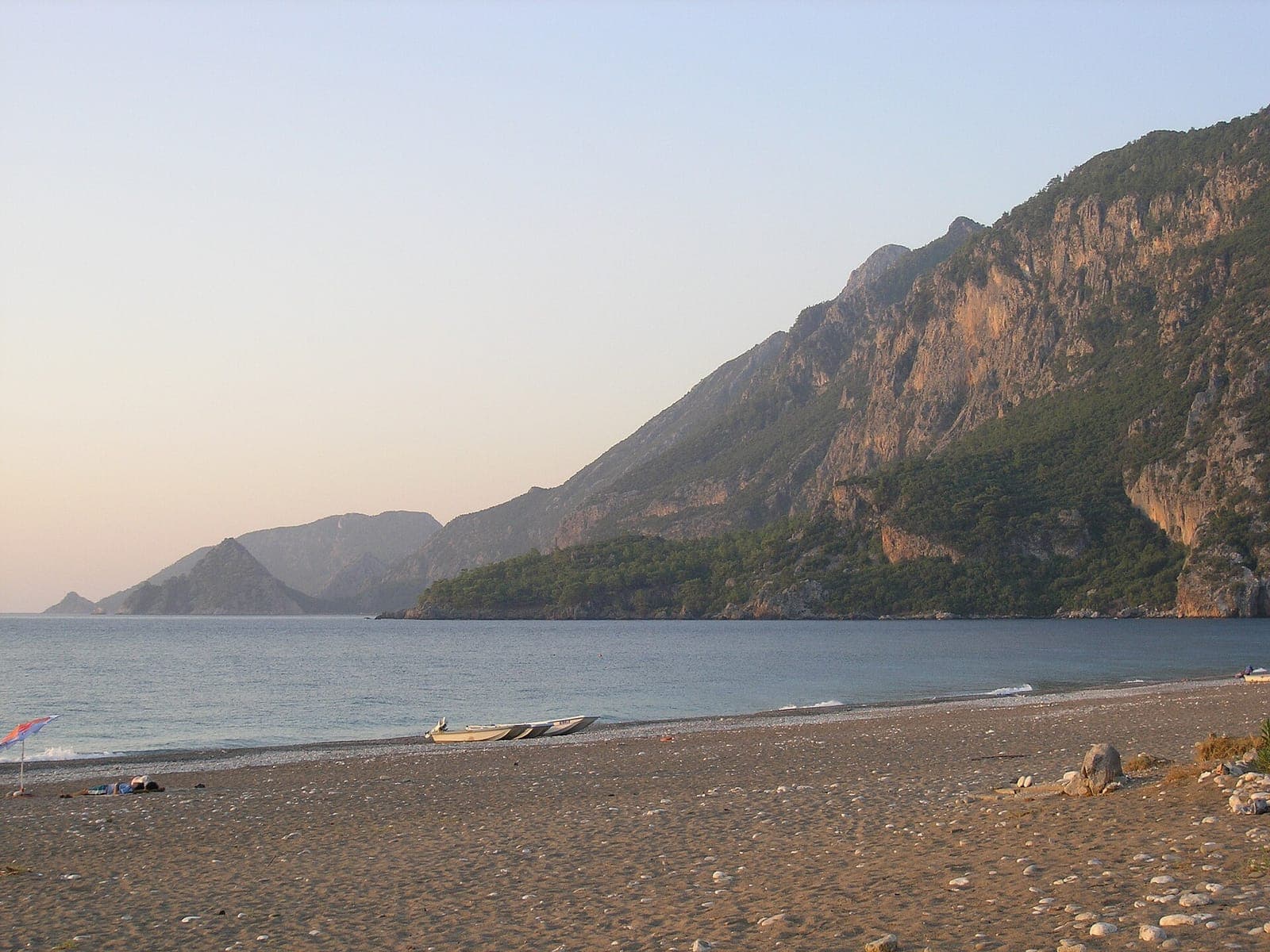 Het strand van Çıralı onder beboste kliffen